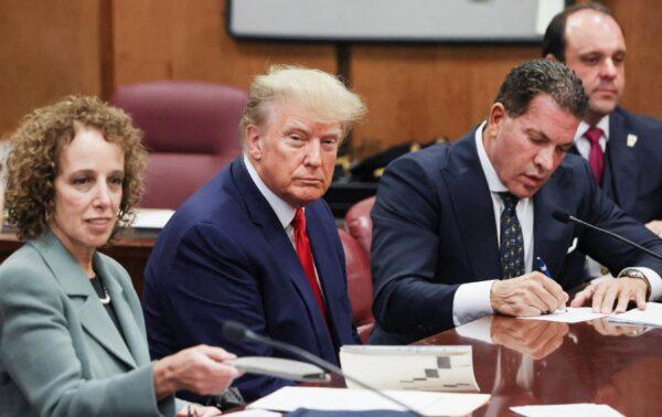 Former U.S. President Donald Trump is accompanied by members of his legal team, Susan Necheles and Joe Tacopina, as he appears in court for an arraignment on charges stemming from his indictment by a Manhattan grand jury, on April 4, 2023. (Andrew Kelly/Reuters)