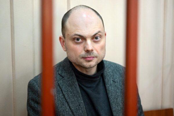 Russian opposition activist Vladimir Kara-Murza sits on a bench inside a defendants' cage during a hearing at the Basmanny court in Moscow on Oct. 10, 2022. (Natalia Kolesnikova/AFP via Getty Images)