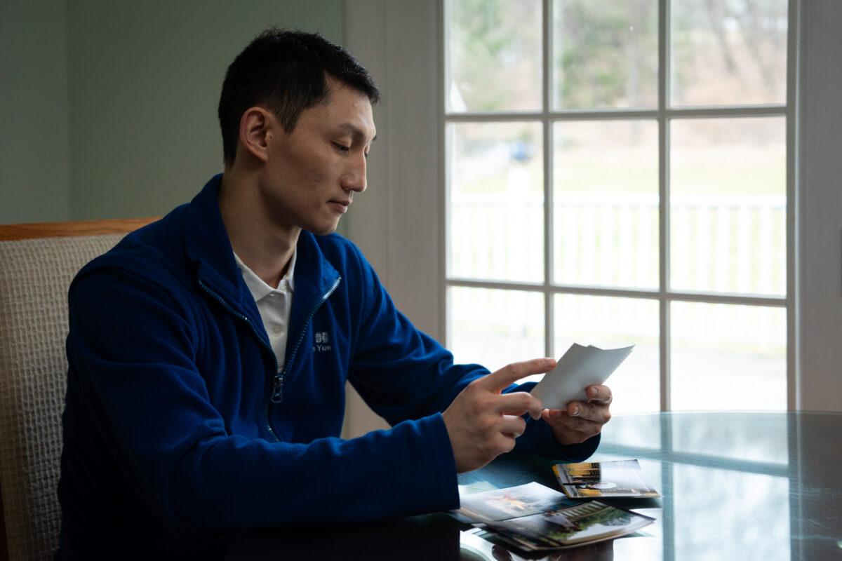 Steven Wang, Shen Yun principal dancer, looks at family photographs at his home in New York state on March 31, 2023. (Samira Bouaou/The Epoch Times)