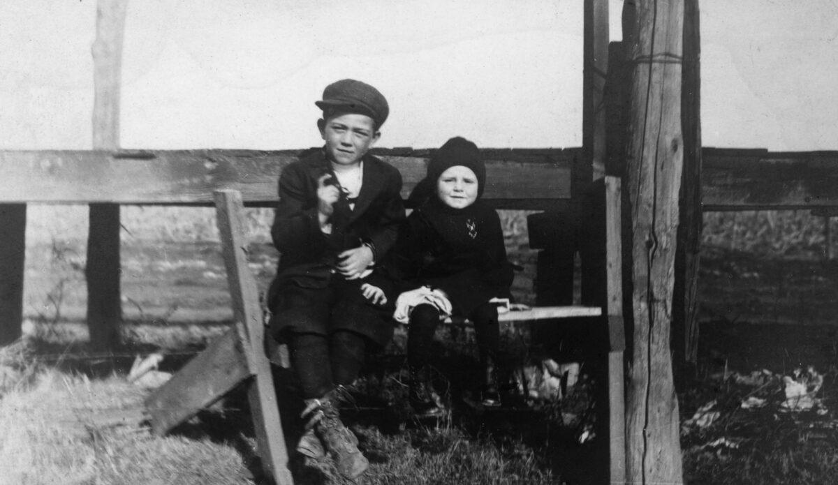 American actor John Wayne as a young boy, sitting against a fence on the prairies with his younger brother Robert. (Photo by Hulton Archive/Getty Images)