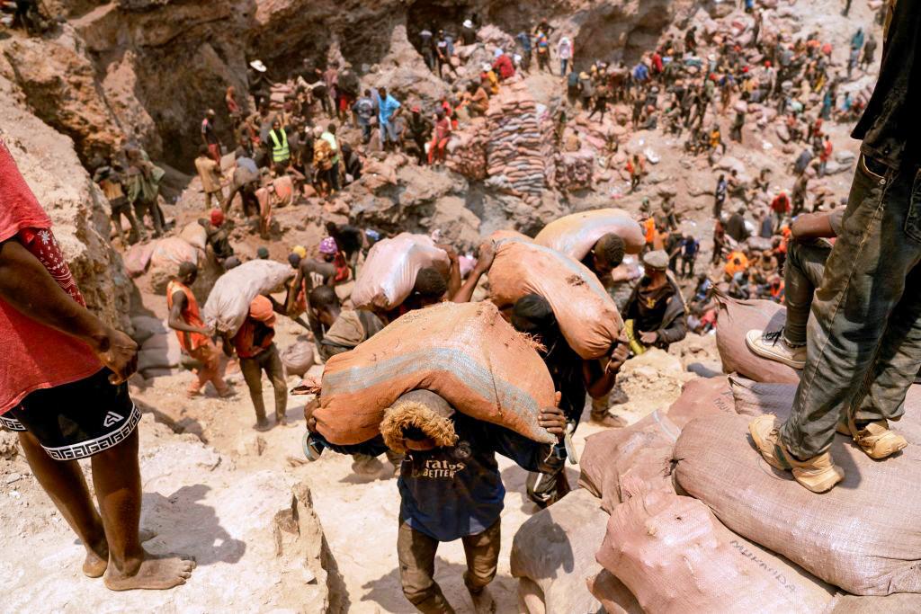 Miners carry sacks of ore at the Shabara artisanal cobalt mine near Kolwezi, Congo, on Oct. 12, 2022. Demand for the metal is exploding due to its use in the rechargeable batteries that power mobile phones and electric cars. (Junior Kannah/AFP via Getty Images)