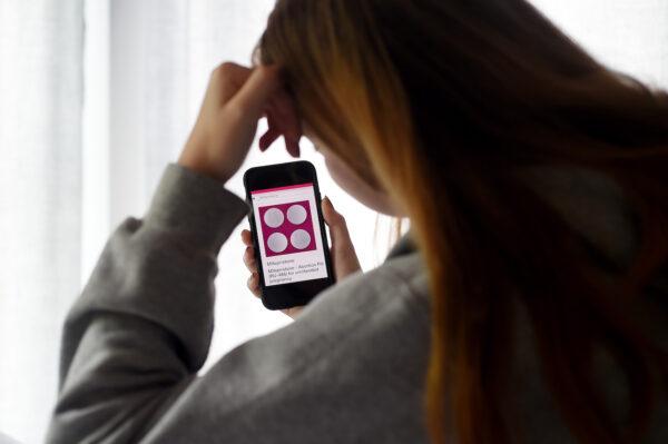In this photo illustration, a person looks at an Abortion Pill (RU-486) for unintended pregnancy from Mifepristone displayed on a smartphone, in Arlington, Va., on May 8, 2020. (Olivier Douliery/AFP via Getty Images)
