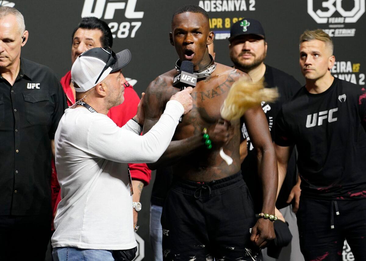 UFC commentator Joe Rogan (front left) listens to Israel Adesanya after a ceremonial weigh-in in Miami on April 7, 2023. (Marta Lavandier/AP Photo)