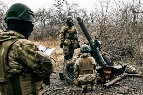Volunteer soldiers prepare to fire toward Russian positions close to Bakhmut, Donetsk region, Ukraine, on March 8, 2023. (Libkos/AP Photo)