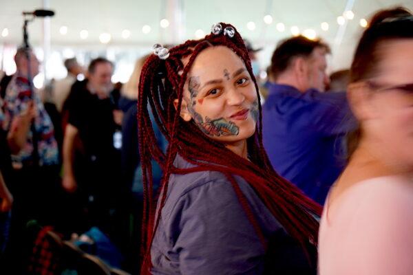 A woman wearing face paint smiles during a prayer service in Bakersfield, Calif., on March 12, 2023. (Allan Stein/The Epoch Times)