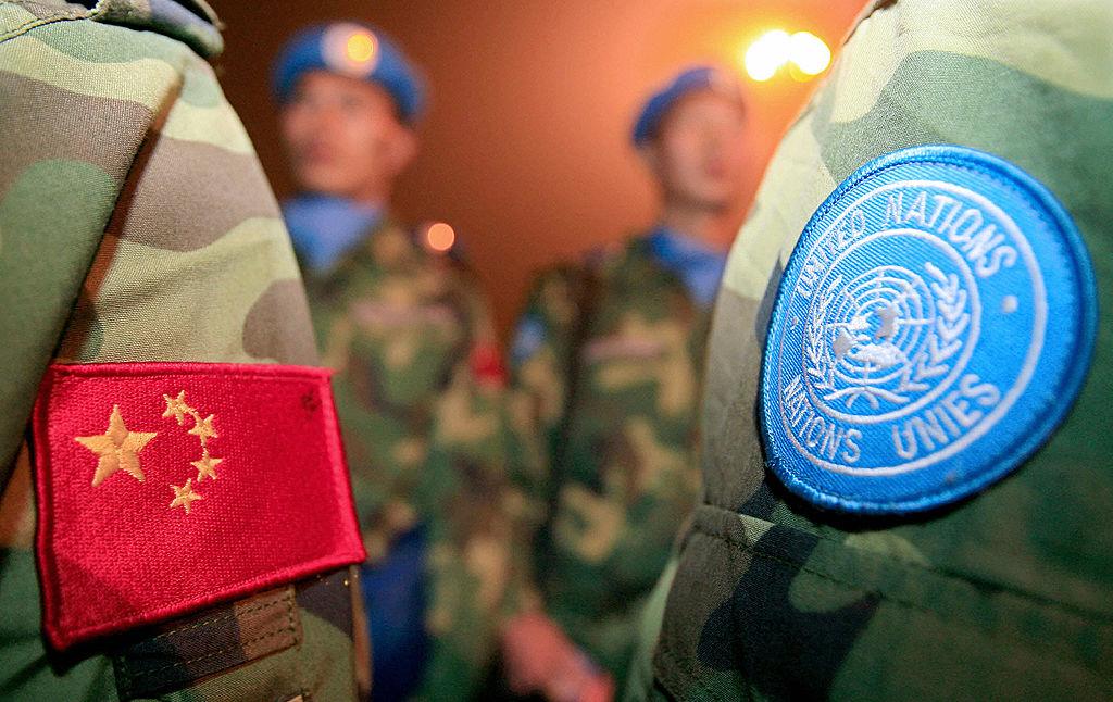 Chinese People's Liberation Army (PLA) soldiers of a Chinese UN peacekeeping unit destined for Darfur in Sudan stand ready to board an aircraft leaving for Sudan at the Xinzheng International Airport in Zhengzhou, central China's Henan Province, 23 Nov. 2007. (Teh Eng Koon/AFP via Getty Images)
