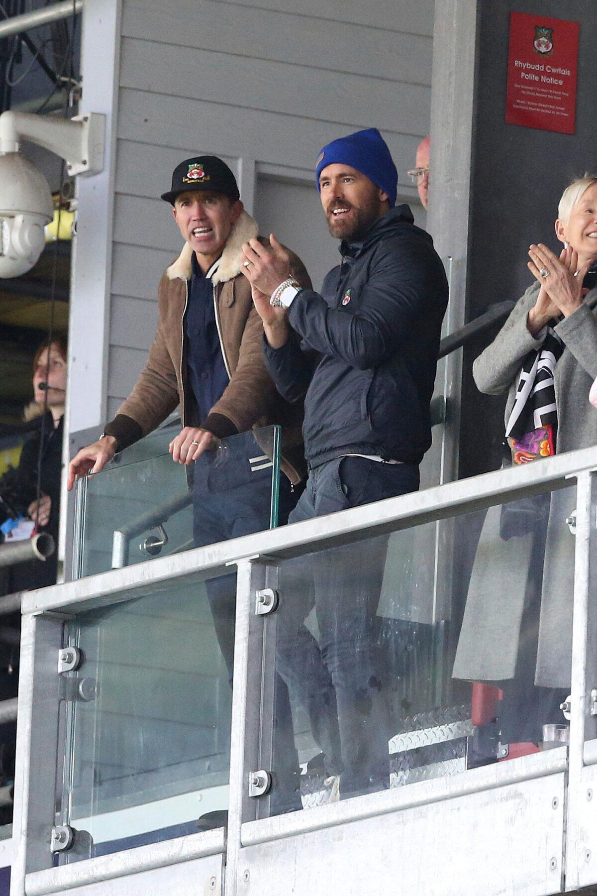 Wrexham owners Ryan Reynolds (R) and Rob McElhenney react during the National League match between Wrexham and Notts County at the Racecourse Ground in Wrexham, Wales, on April 10, 2023. (Barrington Coombs/PA via AP)