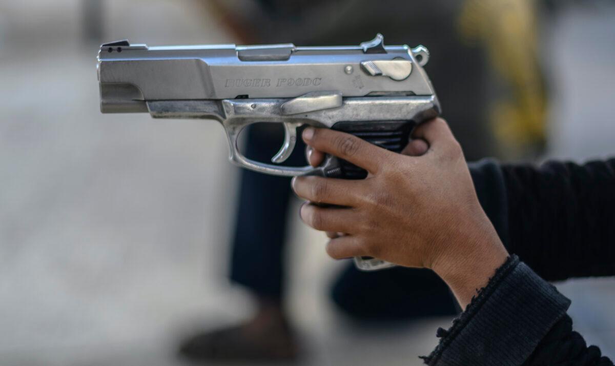 A boy holds a gun as a community police force teaches children how to use weapons in the village of Ayahualtempan, Guerrero State, Mexico, on Jan. 24, 2020. The vigilante group trains children as young as five so they can protect themselves from drug-related criminal groups operating in the area. (Pedro Pardo/AFP via Getty Images)