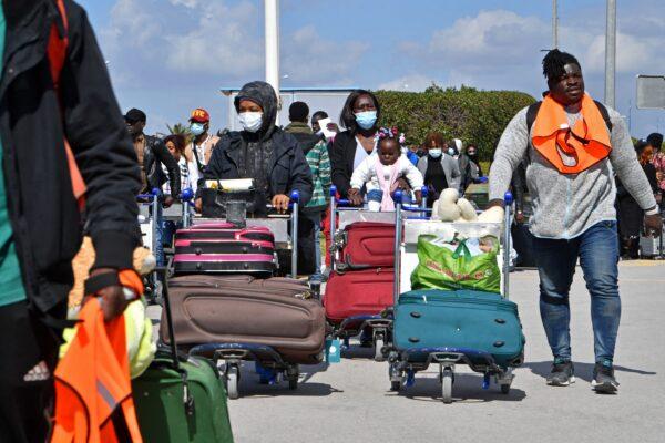 Migrants arrive at Tunis-Carthage International airport as they prepare to leave Tunis on a repatriation flight on March 7, 2023. (FETHI BELAID/AFP via Getty Images)