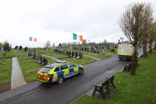 A police car and a British Army truck at Derry City Cemetery, which was temporarily closed as a check was carried out for bombs, following a dissident republican parade in the Creggan area of Londonderry on April 11, 2023. (PA)