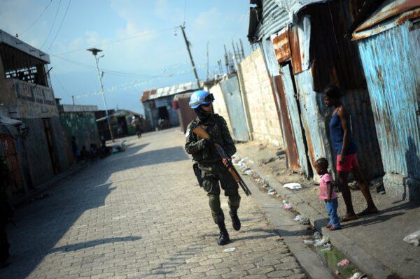 A member of the United Nations Stabilization Mission in Haiti patrols in the Cite Soleil slum of Port-au-Prince on March 11, 2014. (HECTOR RETAMAL/AFP via Getty Images)