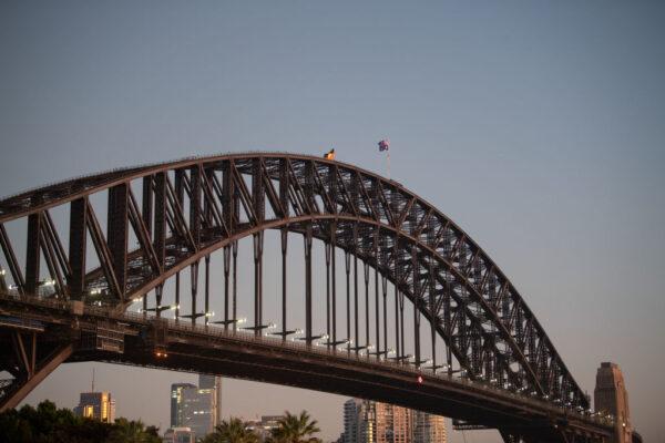 The Aboriginal and Australian national flags fly together on the Sydney Harbour Bridge, in Sydney, Australia, on Jan. 26, 2023. (Wendell Teodoro/Getty Images)
