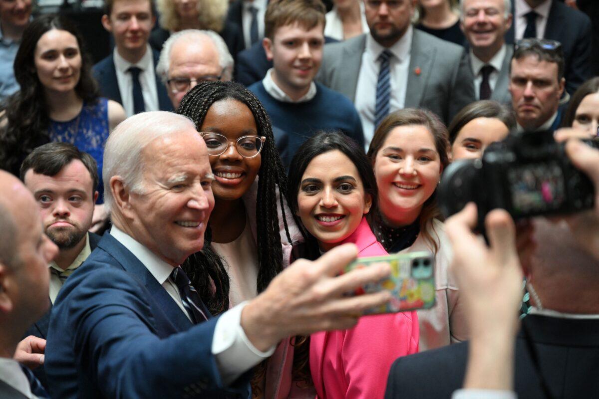 U.S. President Joe Biden poses for a selfie photograph after delivering a speech on business development at Ulster University in Belfast on April 12, 2023. (Jim Watson/AFP via Getty Images)