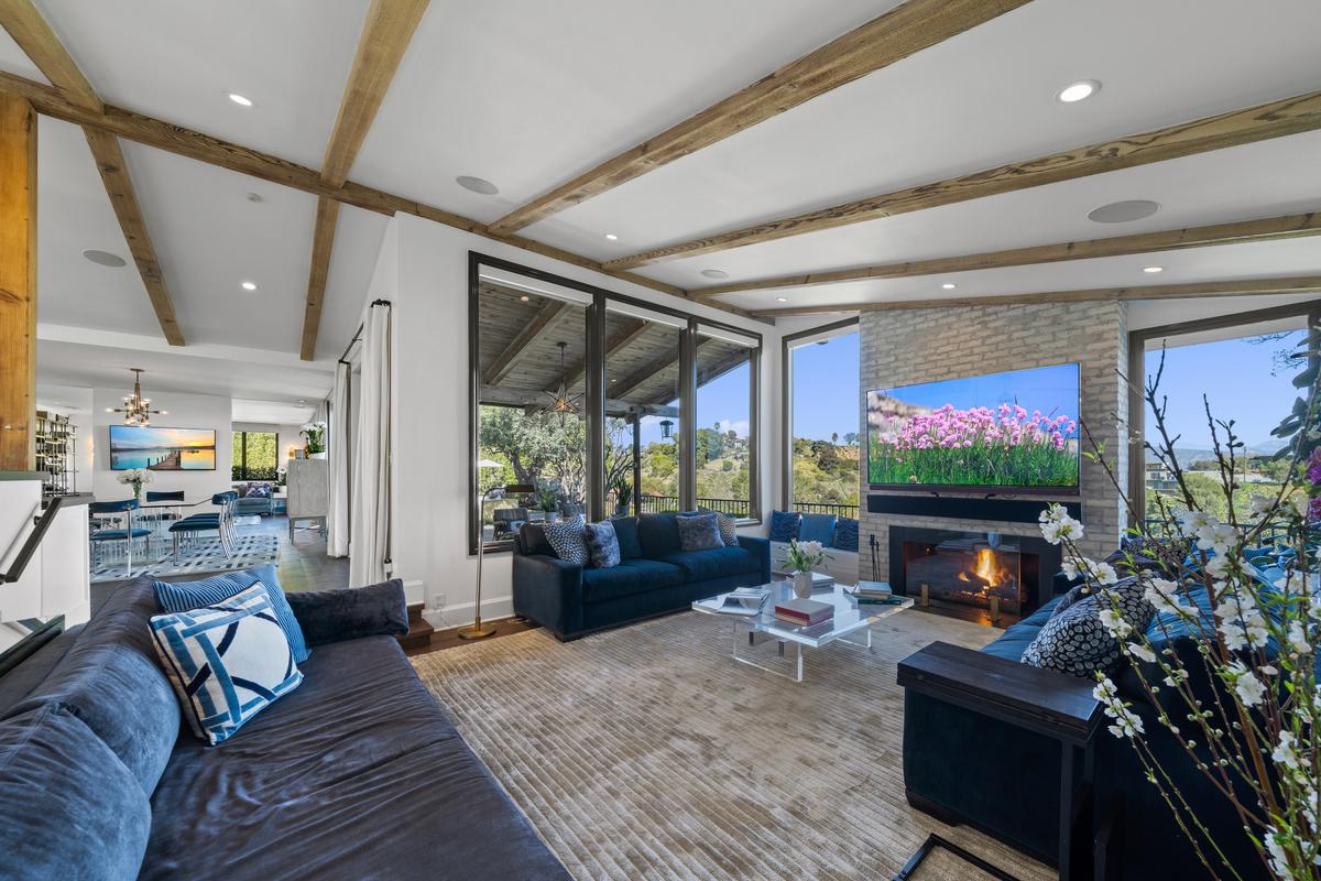 The living room is casual and comfortable, with a fireplace and magnificent views of the nearby foothills. (Courtesy of One Shot Productions, TopTenRealEstateDeals.com)