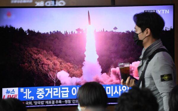 People sit near a television showing a news broadcast with file footage of a North Korean missile test, at a railway station in Seoul, South Korea, on Nov. 18, 2022. (ANTHONY WALLACE/AFP via Getty Images)