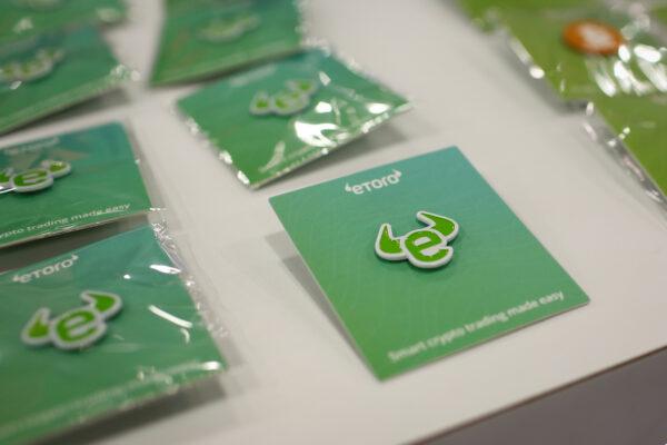 Pins depicting the logo of EToro are seen at a stand during the Bitcoin Conference 2022 in Miami Beach, Fla., on April 6, 2022. (Marco Bello/Reuters)