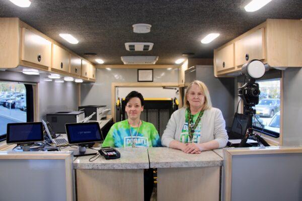 Two employees of the Orange County Clerk's Office stand behind the service counter in the new mobile DMV unit on April 13, 2023. (Courtesy of Orange County Government)