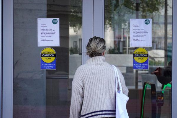 A customer stops to read a sign posted on the front door of a closed Whole Foods store in San Francisco on April 12, 2023. (Justin Sullivan/Getty Images)