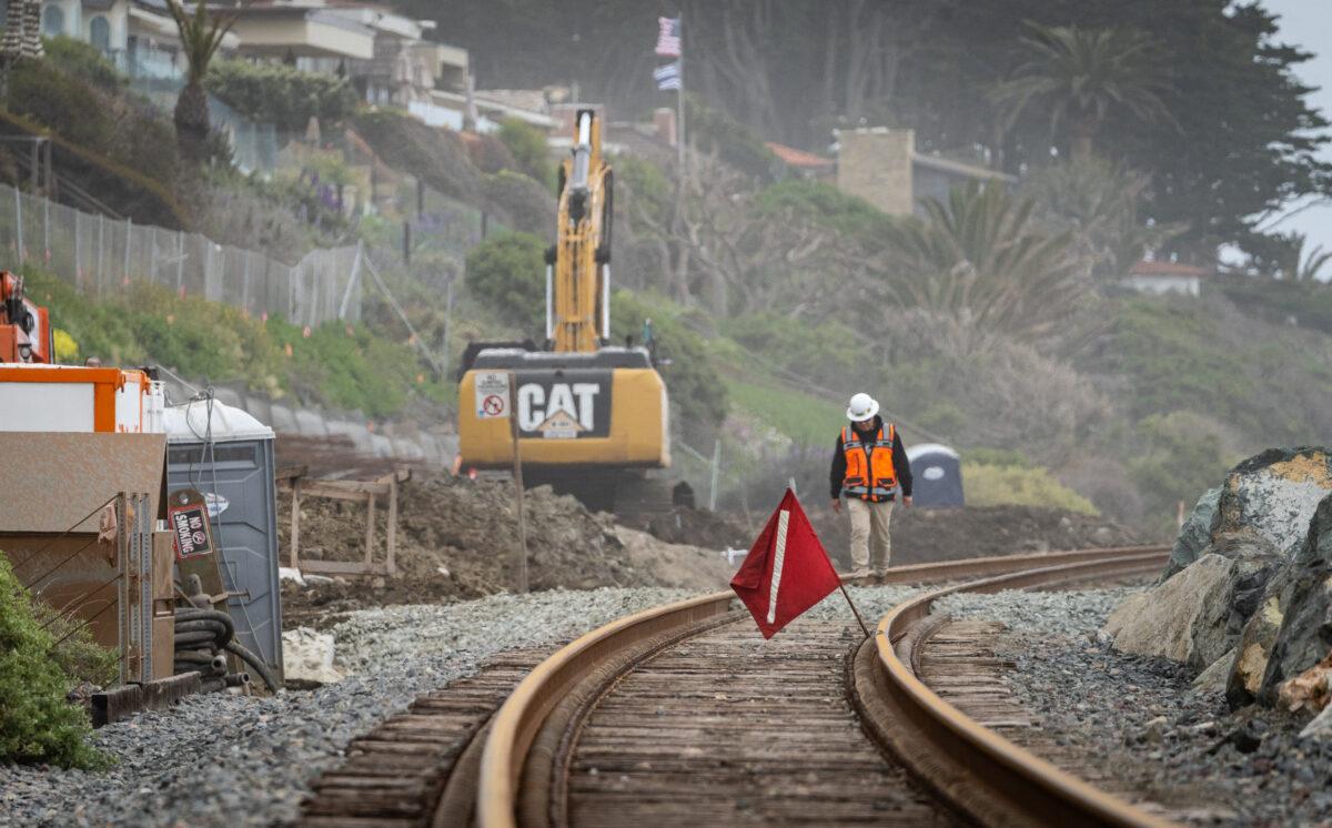 Workers fix the track for the Amtrak coastal railway line in San Clemente, Calif., on April 13, 2023. (John Fredricks/The Epoch Times)