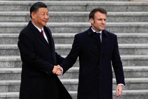 Chinese leader Xi Jinping (L) shakes hands with his French President Emmanuel Macron at the official welcoming ceremony in Beijing on April 6, 2023. (Ng Han Guan/Pool/AFP via Getty Images)