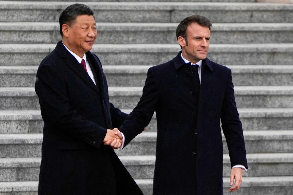 Chinese leader Xi Jinping shakes hands with his French counterpart Emmanuel Macron as they attend the official welcoming ceremony in Beijing on April 6, 2023. (Ng Han Guan/Pool/AFP via Getty Images)