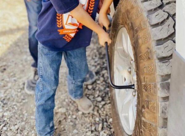 A student changes a tire during Life Skills class. (Courtesy of Melissa Wheeler)
