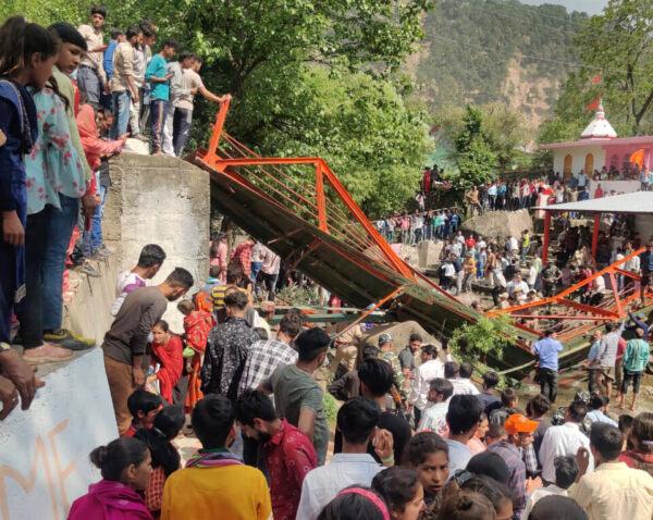 People crowd near a steel footbridge which collapsed during the Baisakhi fair in Udhampur, near Jammu, India, on April, 14, 2023. (AP Photo)