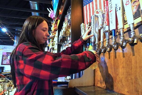 Sydney Encinas, a bartender at The Chaparral Bar in Cottonwood, Ariz., pours a glass of Bud Light on April 14, 2023. (Allan Stein/The Epoch Times)