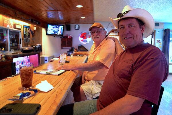 Scott Bradshaw and his grandfather Dale Spude enjoy a drink at the Old Corral Bar in Cornville, Ariz., on April 14, 2023. (Allan Stein/The Epoch Times)