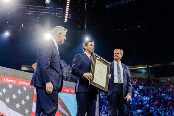 Florida Gov. Ron DeSantis (C) receives an honorary degree of the Doctorate of Humanities at Liberty University from university president Jerry Prevo (L) and pastor Jonathan Falwell in Lynchburg, Va., on Apr. 14, 2023. (Courtesy of Liberty University)