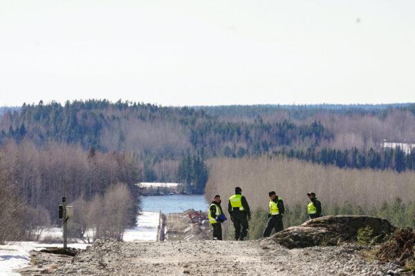 Finnish border guards stand near the border fence with Russia in Pelkola, Finland, on April 14, 2023. (Janis Laizans/Reuters)