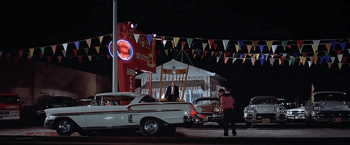 Toad (Charles Martin Smith, R) is about to get the world's most pernicious used-car salesman (John Brent, in big chair), trying to sell him a Corvette and take his '58 Chevrolet Impala, in “American Graffiti.” (Lucasfilm Ltd./The Coppola Company/Universal Pictures)