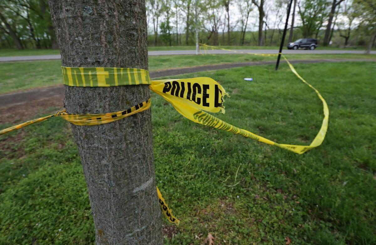 The remnants of police tape are visible near the tennis courts at Chickasaw Park in Louisville, Ky., on April 16, 2023, following a shooting late Saturday night. (Sam Upshaw/Courier Journal via AP)