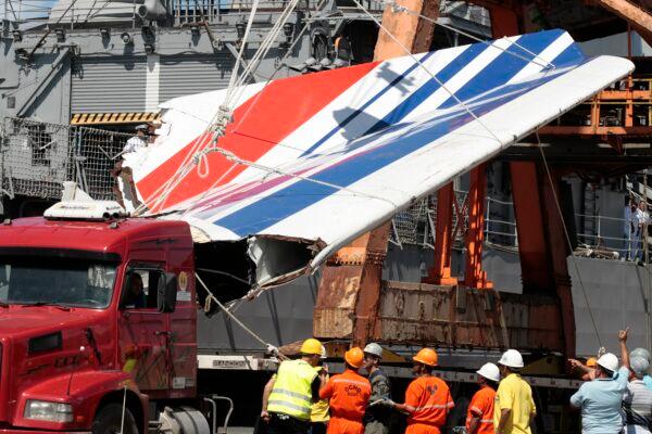 Workers unloading debris, belonging to crashed Air France flight AF447, from the Brazilian Navy's Constitution Frigate in the port of Recife, northeast of Brazil, on June 14, 2009. (Eraldo Peres/AP Photo)