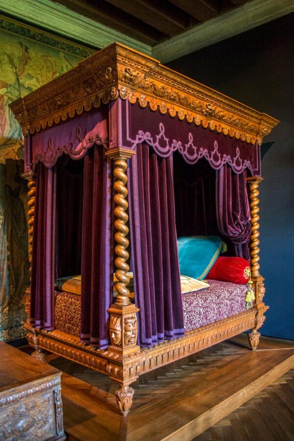 Another highlight of the château: the bedroom of Philippe Lesbahy, the wife of Gilles Berthelot. The focal point of the bedroom is the elevated bed, recreated in the 19th-century Neo-Renaissance style. Purple damask curtains, silk velvet trimmings, embroideries, and elaborate woodwork illustrate the richness of Renaissance beds and the prestige of their owners. At the end of the bed, the trunk is in the Neo-Renaissance style. (Steve Allen/Shutterstock)