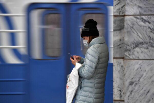 A woman uses her mobile phone at Chkalovskaya metro station in Moscow on Oct. 12, 2020. (Natalia Kolesnikova/AFP via Getty Images)