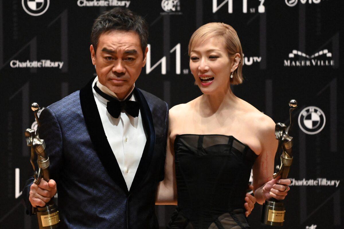 Hong Kong singer and actress Sammi Cheng (R) holds her statuette for winning the Best Actress award with Hong Kong actor Sean Lau, who won the Best Actor award at the 41st Hong Kong Film awards in Hong Kong on April 16, 2023. (Peter Parks/AFP)