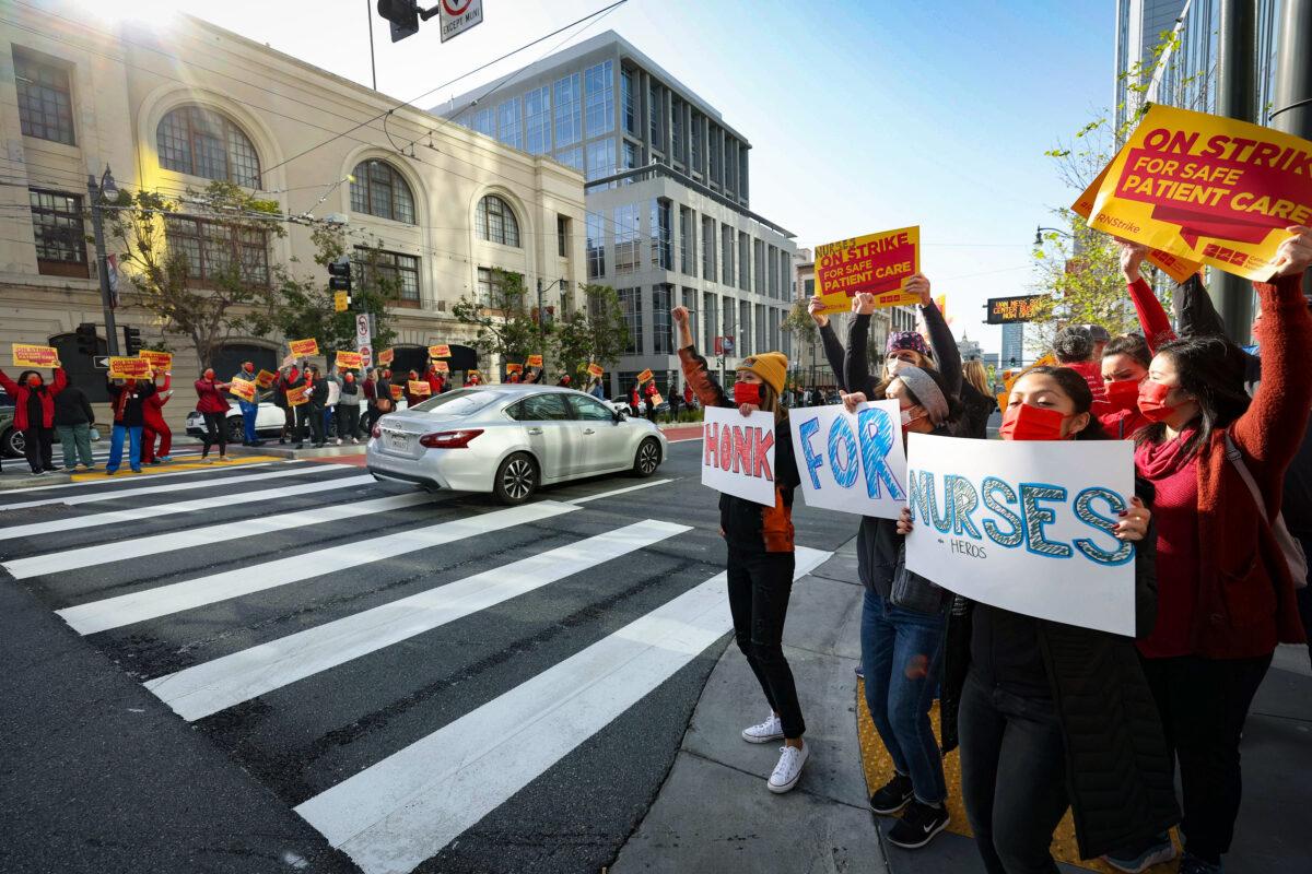 Sutter Health nurses and health care workers hold signs as they participate in a one-day strike outside of the California Pacific Medical Center Van Ness Campus in San Francisco on April 18, 2022. (Justin Sullivan/Getty Images)