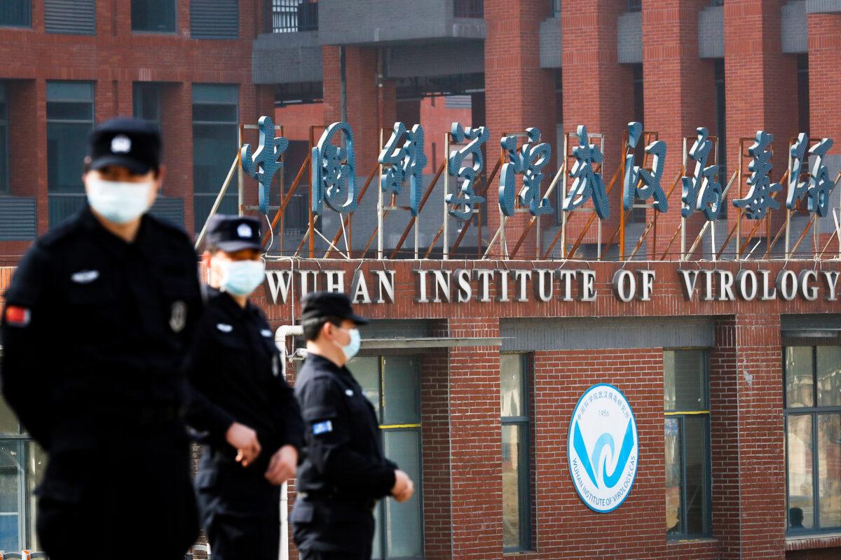 Security personnel keep watch outside the Wuhan Institute of Virology during the visit by the World Health Organization team tasked with investigating the origins of COVID-19, in Wuhan, Hubei Province, China, on Feb. 3, 2021. (Thomas Peter/Reuters)