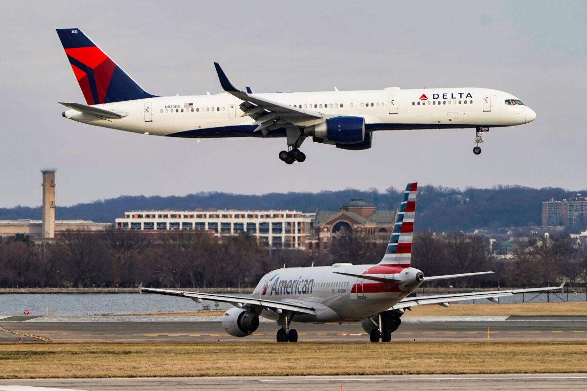 An American Airlines plane taxis as a Delta Air Lines aircraft lands at Reagan National Airport in Arlington, Va., on Jan. 24, 2022. (Joshua Roberts/Reuters)