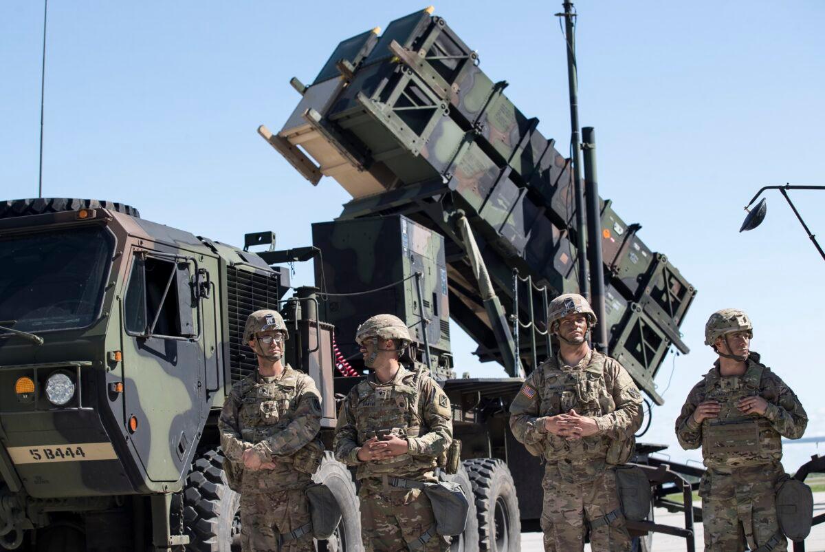 Members of U.S. 10th Army Air and Missile Defense Command stands next to a Patriot surface-to-air missile battery during the NATO multinational ground based air defence units exercise "Tobruq Legacy 2017" at the Siauliai airbase some 230 kilometers (144 miles) east of the capital Vilnius, Lithuania, on July 20, 2017. (Mindaugas Kulbis/AP Photo)