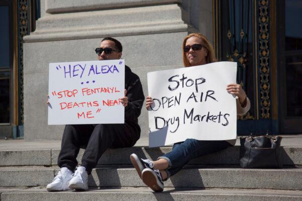People hold signs at a rally in front of San Francisco City Hall on April 16, 2023, to call for safer streets without open-air drug markets. (Lear Zhou/The Epoch Times)