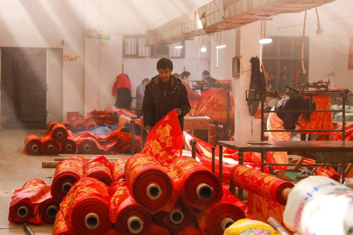 A worker checks cloth at a textile factory in Hangzhou in China's eastern Zhejiang province on Jan. 6, 2023. (STR/AFP via Getty Images)