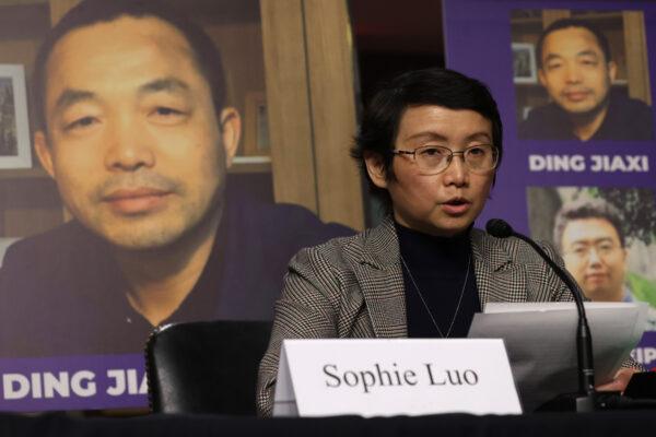 As a photo of her husband Chinese human rights activist Ding Jiaxi is on display in the background, Sophie Luo testifies during a hearing before The Congressional-Executive Commission on China (CECC) at Dirksen Senate Office Building on Capitol Hill in Washington on Feb. 3, 2022. (Alex Wong/Getty Images)