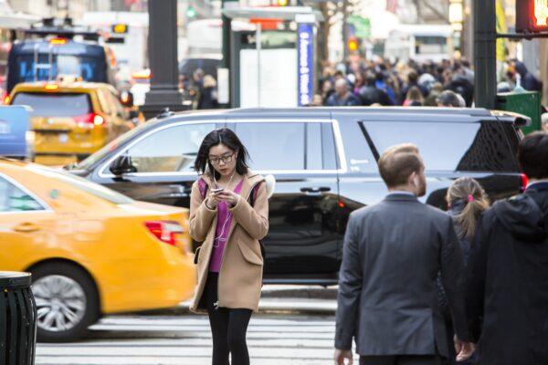 A girl with her phone in Manhattan, New York, on Feb. 27, 2017. (Samira Bouaou/The Epoch Times)