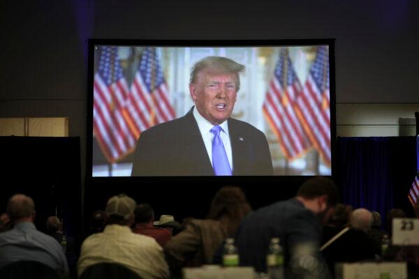 Guests watch former President Donald Trump speak on a recorded video at the Iowa Faith & Freedom Coalition in Clive, Iowa, on April 22, 2023. (Madalina Vasiliu/The Epoch Times)
