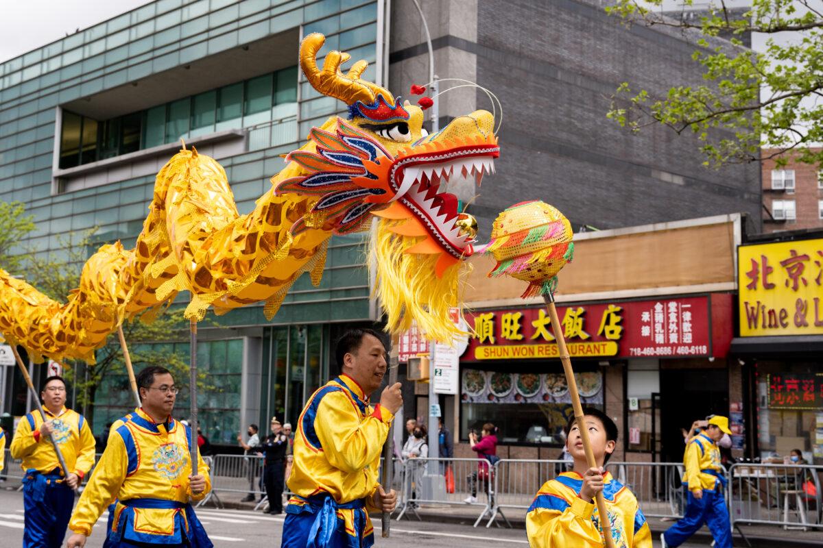 Falun Gong practitioners participate in a parade to call for an end to the Chinese Communist Party's persecution of their faith in the Flushing neighborhood of Queens, N.Y., on April 23, 2023. (Chung I Ho/The Epoch Times)