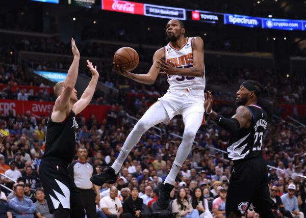 Kevin Durant (35) of the Phoenix Suns scores on a layup between Mason Plumlee (44) and Robert Covington (23) of the LA Clippers during a Suns win in Game Four of the Western Conference First Round Playoffs in Los Angeles on April 22, 2023.(Harry How/Getty Images)