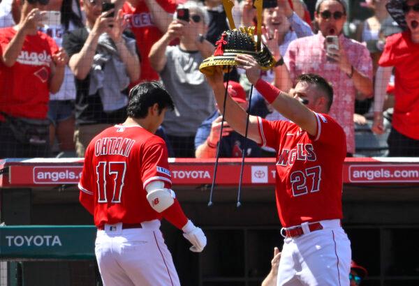 Mike Trout (27) of the Los Angeles Angels places a Samurai Warrior hat on Shohei Ohtani (17) after Ohtani hit a solo home run in the sixth inning against the Kansas City Royals at Angel Stadium of Anaheim in Anaheim, Calif., on April 23, 2023. (Jayne Kamin-Oncea/Getty Images)