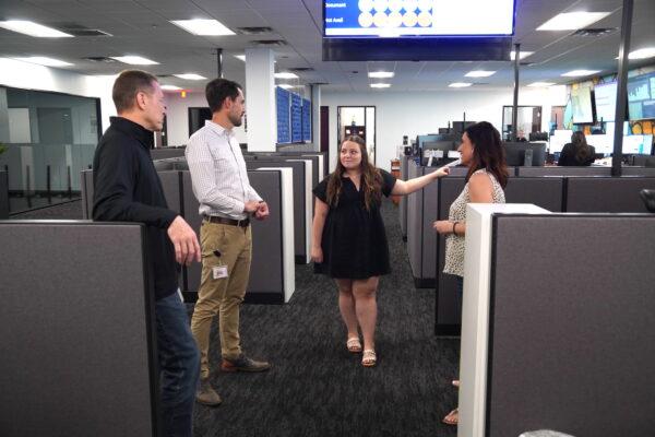 Solari Crisis and Human Services employees confer at the organization's call center in Tempe, Ariz., on April 13, 2023. (Allan Stein/The Epoch Times)